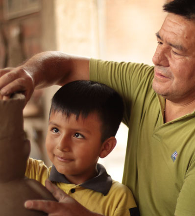 Walter Jose Acosta teaches his son how to sculpt